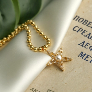 Macro detail of star pendant necklace with gold beads, pearl inlay and zircon crystals