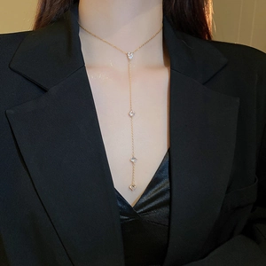 Vue détaillée d'un collier en Y doré avec pendentif cœur et zircone porté par un mannequin