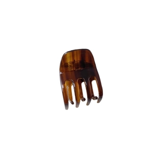 Classic tortoiseshell brown acetate hair claw clip with hollow design on white background