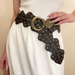 Detailed macro view of the wide vintage brown leather belt with carved brass buckle detail