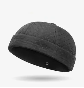 Detail of black quilted dock hat featuring a metal Sports Style badge and side eyelets