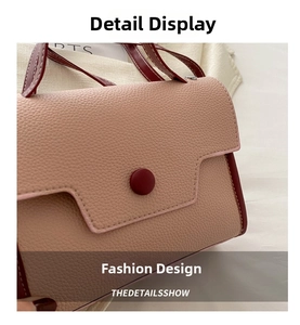 Close-up of pink and burgundy textured leather crossbody bag with decorative red button