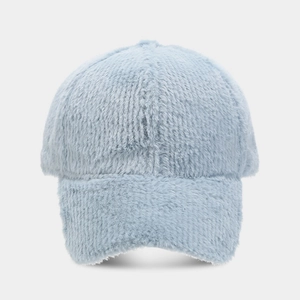 Détail de la texture douce en fausse fourrure bleu clair sur une casquette d'hiver