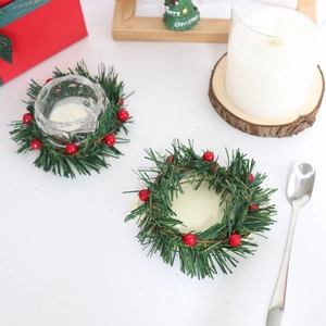 Artificial Christmas holly berry candle ring wreath with a clear glass candle holder cup