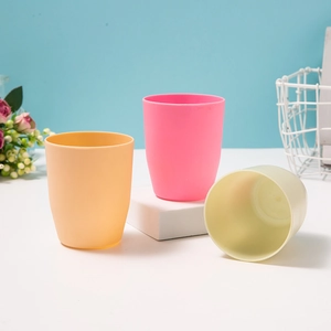 Set of minimalist plastic travel cups in orange, pink and beige with a matte finish