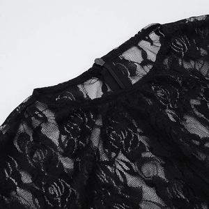 Dettaglio del pizzo floreale e della cerniera nascosta su un abito nero elegante