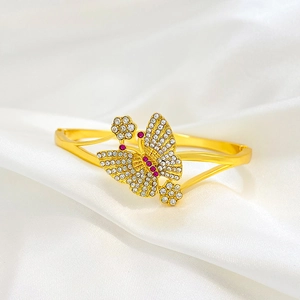 Retro Armreif mit Schmetterling und Blume in Gold mit Kristallen auf weißer Seide