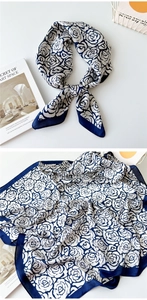 Close-up of blue and white rose pattern silk scarf with elegant floral texture