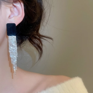 Modella che indossa orecchini vintage con nappe quadrate e strass scintillanti eleganti