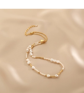 Detailed view of Baroque freshwater pearls and golden metal beads on silk fabric