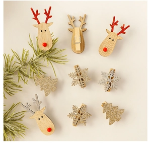 Flat lay of wooden Christmas clips featuring reindeer, snowflakes and trees in festive style