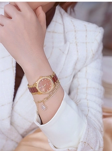 Close-up of luxury gold rhinestone watch and daisy bracelet on woman's wrist