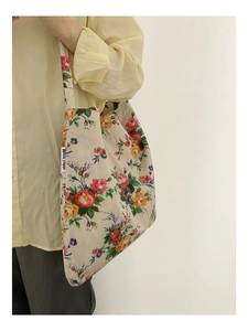 Detail of floral canvas tote bag with Merci Lapin label and colorful flower pattern