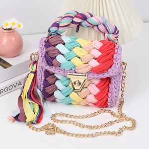 Detail of handmade rainbow crochet bag with gold chain strap and colorful fringe tassel