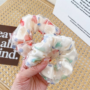 Close-up of floral organza scrunchies showing translucent fabric and elastic texture