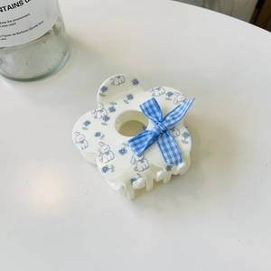 Close-up of flower hair claw clip with blue rabbit print and a plaid ribbon bow