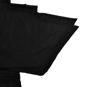 Détail du tissu en maille superposé d'une robe noire à une épaule avec texture