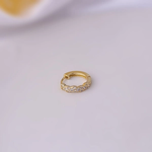 Macro detail of gold plated cuff earring featuring micro-pave cubic zirconia crystals