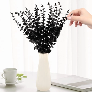 Macro view of black artificial eucalyptus stems in a white vase for home decor