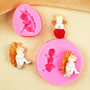 Moules en silicone rose pour anges et cœurs avec des exemples d'anges en fondant