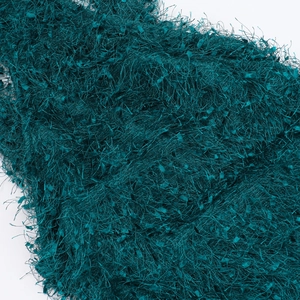 Macro detail of the dark forest green plush textured fabric with long soft faux fur fringe