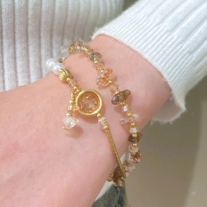 Détail d'un bracelet doré vintage avec pierres naturelles brunes et cristaux