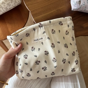 Close-up of floral cotton makeup bag with metal zipper and Simple Wish fabric label