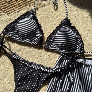 Détails à plat d'un haut de bikini rayé noir et blanc et bas à pois avec des volants