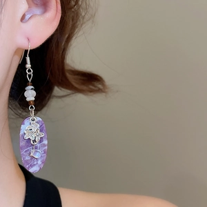Detailed close-up of bohemian earring featuring purple marble pendant and silver floral motif