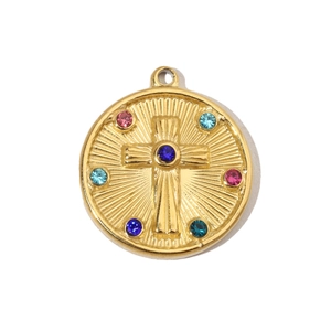 Macro view of a gold-tone round pendant featuring a cross relief and colorful gemstones