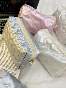 Quilted heart cosmetic bags in metallic silver, pink, and white with bow embossing