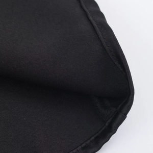 Macro shot of high-quality black satin fabric showing detailed sewing and woven texture