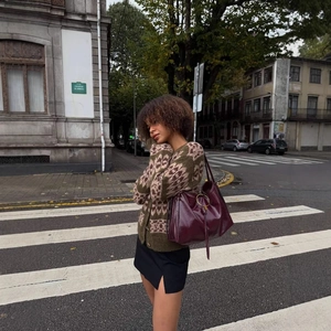 Vintage geometric knit cardigan and glossy leather bag set in city street photography
