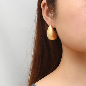 Boucle d'oreille goutte en acier inoxydable doré 18K portée par un mannequin