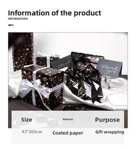 Detail of black and gold foil gift wrap with crown patterns, cards and satin ribbons