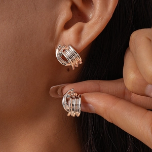 Silver multi-layer geometric C-shaped earrings with a metallic finish shown on model