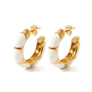 Gold-plated C-shaped chunky hoop earrings with white enamel stripes on a white background