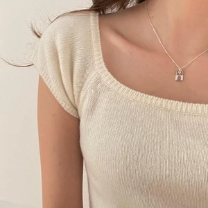 Minimalist 925 sterling silver necklace with small red gemstone pendant on a model