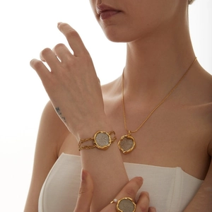 Detailed set of vintage gold lucky coin necklace, bracelet and ring on a model