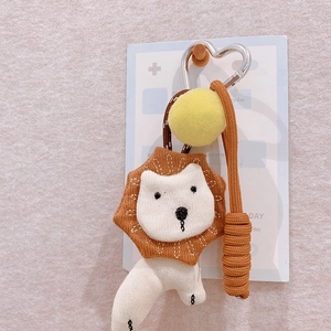 Close-up of a handmade lion knit keychain with brown braided rope and a heart-shaped clasp