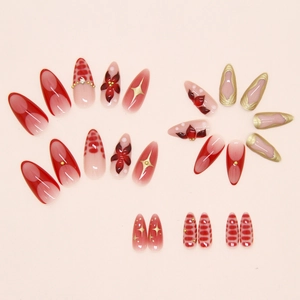 Detail of burgundy camellia press-on nails with 3D pearls and gold floral patterns