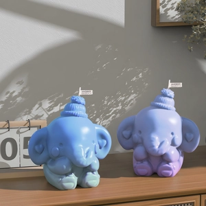 Handmade elephant scented candles in blue and gradient purple with knitted hat detail