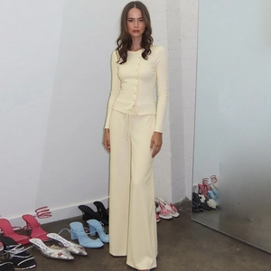 Detailed texture of light yellow ribbed knit cardigan and high waist wide leg pants set