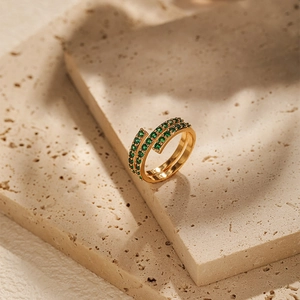 Macro detail of 18K gold plated wrap ring with double rows of green cubic zirconia stones