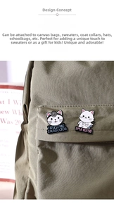 Detail of cartoon doctor cat and nurse cat enamel pins on a dark green canvas bag