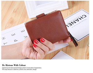 Close-up of brown faux leather wallet showing fine lychee grain and secure metal zipper