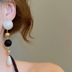 Detail of vintage 18k gold plated drop earrings with white pearls on a model side view