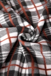 Detailed macro view of the soft grey and orange plaid fleece texture on a warm sweater