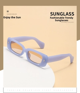 Detail of square sunglasses with purple frame, orange lenses, and polarized light feature