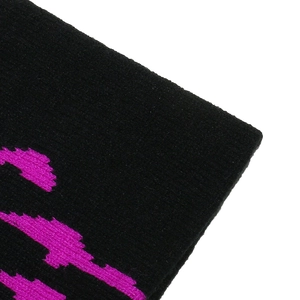Dettaglio ricamo zucca rosa su berretto in maglia nera con trama ben definita